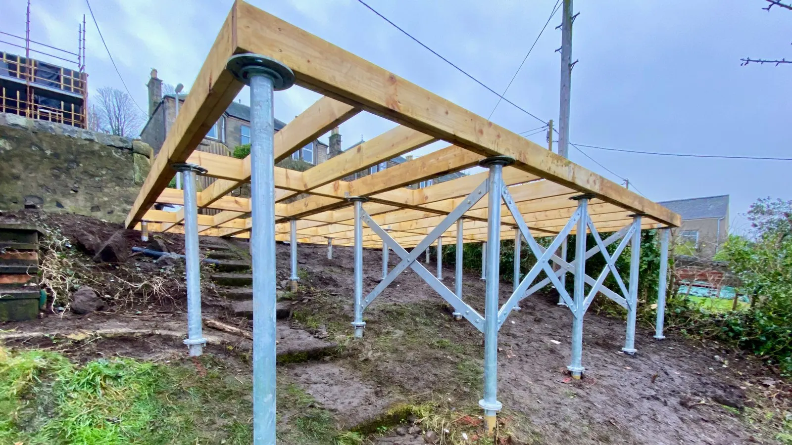 A level timber garden-room sub-frame built on a concrete-free ground screw foundation