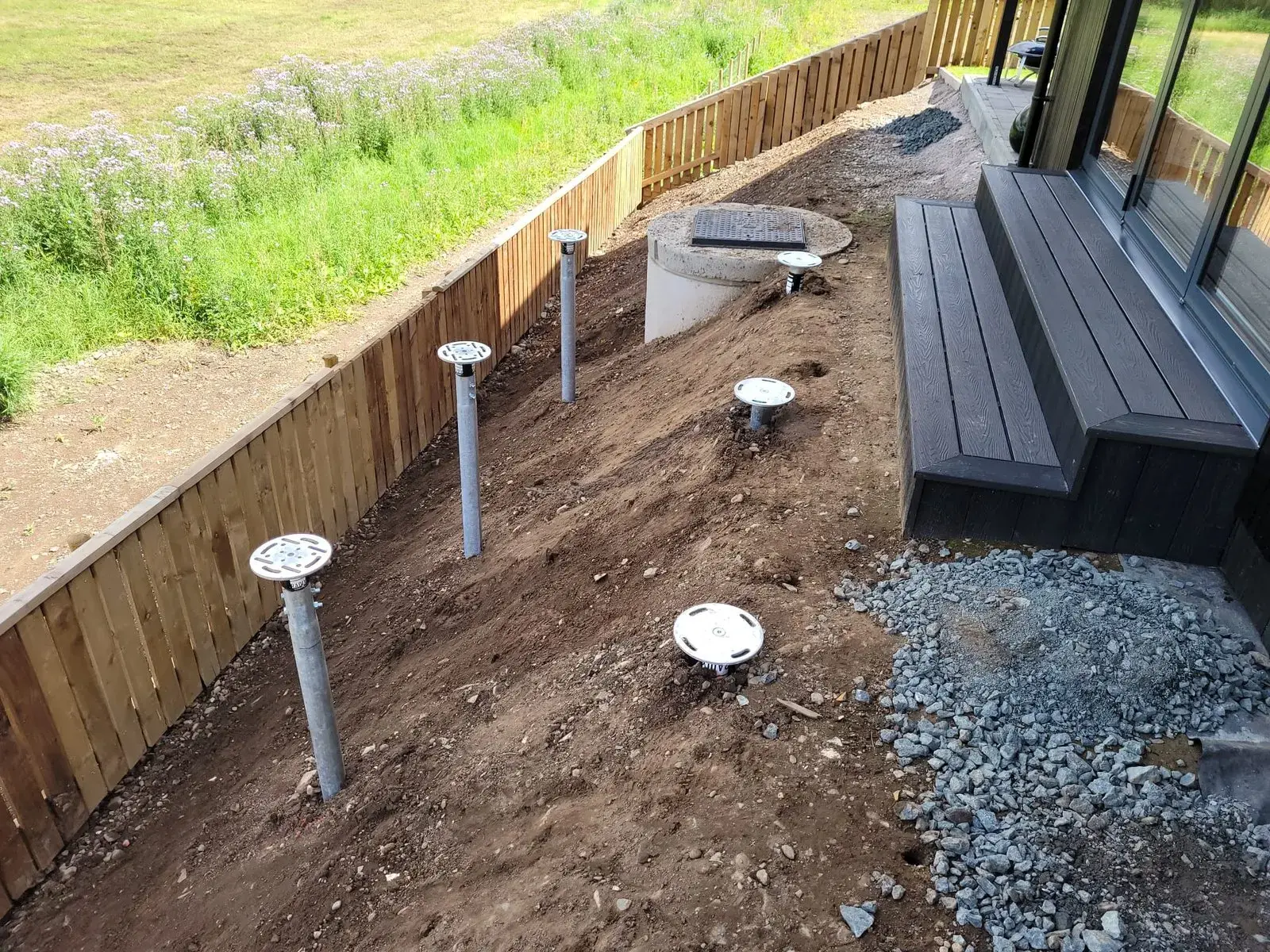 Ground screws anchored through clay soil to stable strata